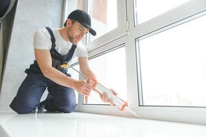 Construction worker installing window in house photo