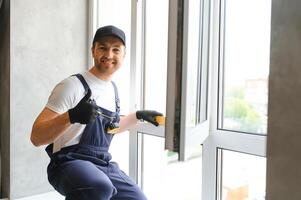 The foreman installs a window frame in the room photo