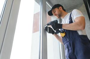 The foreman installs a window frame in the room photo