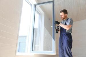 Construction worker installing new window in house photo