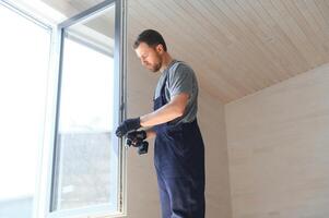 A worker installs windows in a new modular home. The concept of a new home. photo