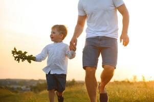 Happy father playing with son on sunset background .The concept of father's day photo