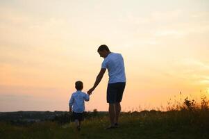 Father's day. Happy family father and toddler son playing and laughing on nature at sunset photo
