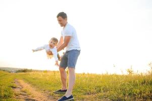 Father's day. Happy family father and toddler son playing and laughing on nature at sunset photo