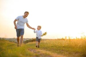 Father's day. Happy family father and toddler son playing and laughing on nature at sunset photo