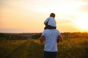 Father's day. Happy family father and toddler son playing and laughing on nature at sunset photo