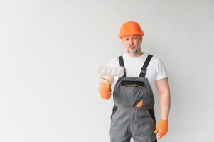 Painter using a paint roller and painting a wall isolated on white background. photo