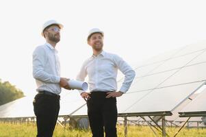 ingeniero y empresario cepillado nuevo ecología proyecto. alrededor solar panel. foto