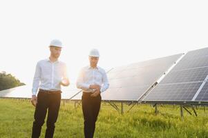 ingeniero y empresario cepillado nuevo ecología proyecto. alrededor solar panel. foto