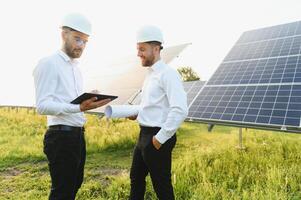 ingeniero y empresario cepillado nuevo ecología proyecto. alrededor solar panel. foto