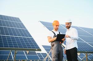 dos profesional contratistas discutir final resultado de solar panel instalación foto