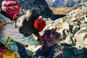 Professional nepalese guide use oxygen finger monitor to check woman trekker blood oxygen levels. Himalayas high altitude feeling low oxygen level affects of dizziness and weakness photo