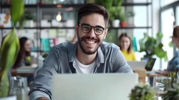 Happy Young Brand Strategist Working Diligently on Laptop in Modern Office Environment photo