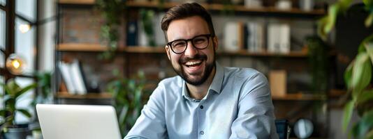 Cheerful Young Businessman Working on Laptop in Cozy Office Environment photo