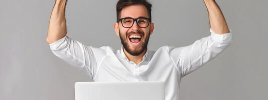 Elated Young Professional Celebrating Success at Computer Workspace photo