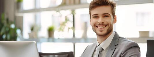 Confident Young Corporate Professional Working at Desk with Laptop photo