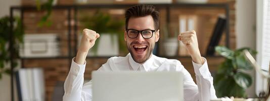 Joyful Young Businessman Celebrating Successful Completion of Accounting Tasks at His Desk photo