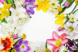 Border of bright spring flowers encircles a blank white space, ideal for adding text or design elements to seasonal graphics and invitations photo
