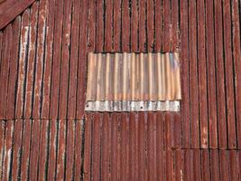 old and rusty zinc sheet roof with one block sheet turning white photo
