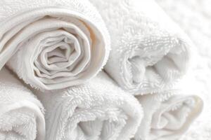 Close-up of neatly rolled white towels stacked on top of each other, creating a fresh and inviting spa-like atmosphere. photo