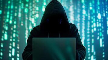 hacker in hoodie with no face using laptop computer on digital background. cyber crime and internet fraud prevention photo