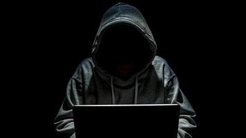 hacker with laptop computer on dark background photo
