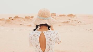 Female vlogger tourist content creator visit explore take photo of Fossil Dunes Structures in desert. Abu Dhabi, UAE. Famous travel destination and Star War movie filming location video