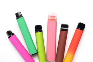 A set of colorful disposable electronic cigarettes of different shapes on a white background. modern smoking. photo