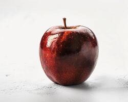 a red apple sitting on a white surface photo