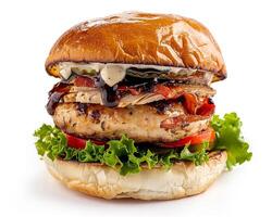a large burger with meat and vegetables on a bun photo
