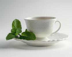 a cup and saucer with a green leaf on it photo