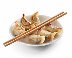 dumplings with chopsticks on a white plate photo