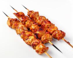 a white background with a skewer of chicken photo