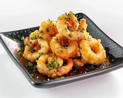 a plate of fried shrimp on a white table photo