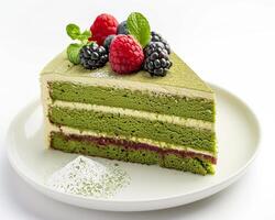 a piece of cake with berries and green tea photo