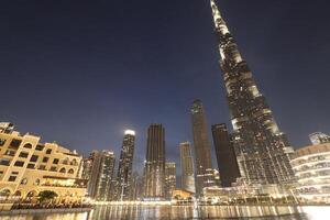 uae, dubai , 1th December 2022 a picture of the burj khalifa with towers and buildings in the night with small lake photo