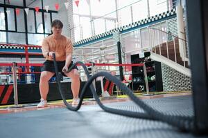 An overweight man is holding a rope and appears to be exercising photo