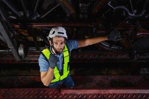 man in a yellow vest is standing on a platform, looking down at a train photo