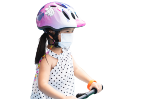 Kid girl is riding a bicycle or scooter wearing helmet and protective mask, showing concern for safety and health. Safety and self-care in children's outdoor activities during the time of the pandemic png