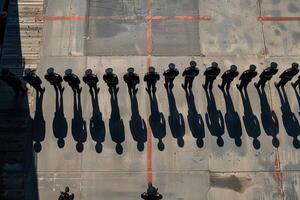 A group of men stand in a circle, with some of them wearing military uniforms photo