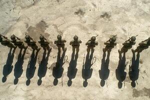 A group of men stand in a circle, with some of them wearing military uniforms photo