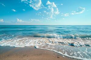 Soft waves are gently lapping at a sandy beach on a beautiful sunny day photo
