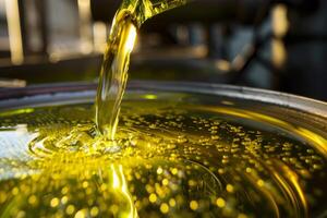 Golden liquid being poured into container at food processing plant photo