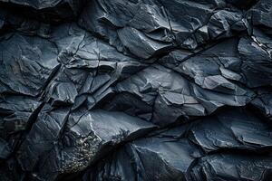 Dark grey rock face texture forming an abstract rugged background photo