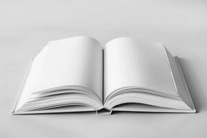 Open book lying on white table is displaying blank pages photo