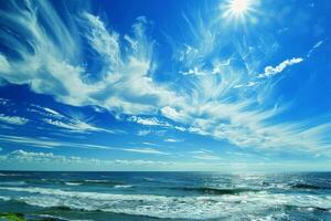 Sun shining over ocean with cirrus clouds in blue sky photo
