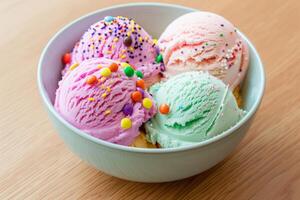 Four scoops of ice cream with sprinkles resting in a bowl photo