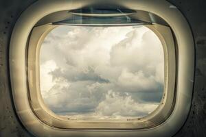 Airplane window view on a cloudy sky photo