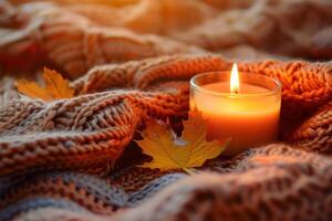 Cozy autumn ambiance with candle and knitted blanket photo