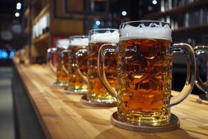 Row of full beer mugs standing on bar counter in a pub photo